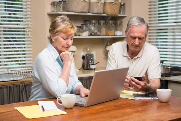 An older couple looking at financial documents together at their dining room table. The room is bright and sunny.