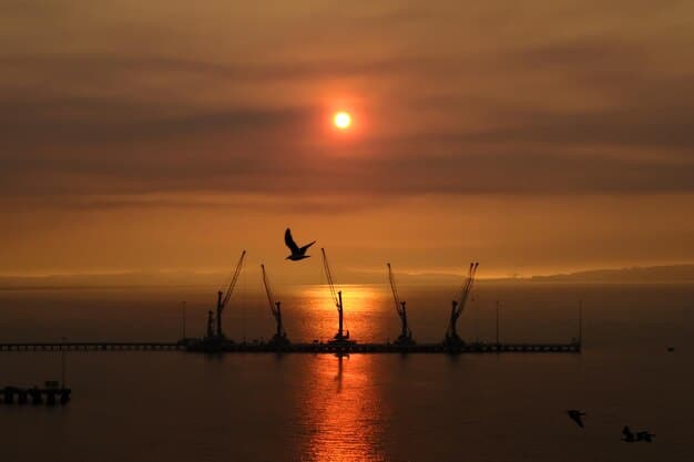 An illustration of wind turbines at an offshore wind farm during sunset, showing reflections on the tranquil sea and connecting cables to indicate power transport. The image highlights clean energy generation and technology.